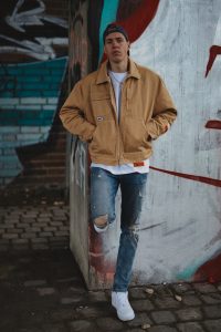 man standing against wall with jacket